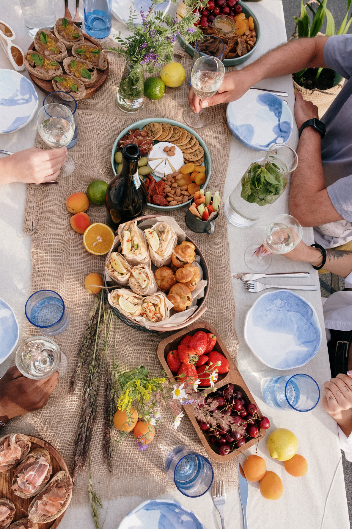 Person in Blue T-shirt Sitting on Chair in Front of Table With Foods